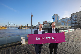 Präses Thorsten Latzel und Oberbürgermeister Stephan Keller mit Losung des Kirchentages 2027 in Düsseldorf