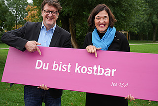 Präsident Torsten Zugehör und Generalsekretärin Kristin Jahn mit Losung des Kirchentages 2027 in Düsseldorf