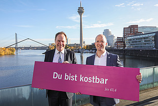 Oberbürgermeister Stephan Keller und Präses Thorsten Latzel mit Losung des Kirchentages 2027 in Düsseldorf