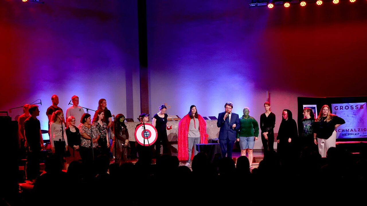 Bühne in der Jungen Kirche Lux mit Gruppe von verkleideten Superheld:innen