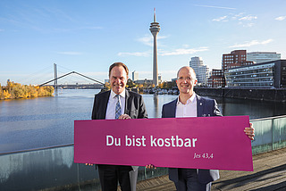 Oberbürgermeister Stephan Keller und Präses Thorsten Latzel mit Losung des Kirchentages 2027 in Düsseldorf