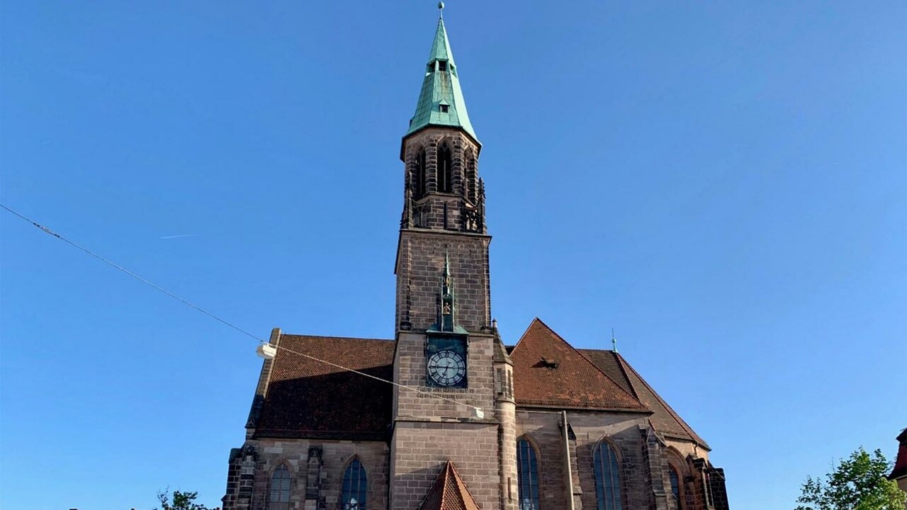 Kirche Sankt Peter mit einem Kirchturm in der Mitte vor blauem Himmel