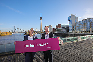 Präses Thorsten Latzel und Oberbürgermeister Stephan Keller mit Losung des Kirchentages 2027 in Düsseldorf