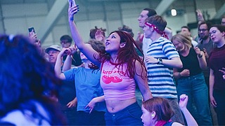 Besucherinnen tanzen beim Fusion-Rave und machen ein Selfie