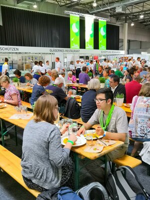 Gläsernes Restaurant in Messehalle in Dortmund 2019 mit vielen Menschen.