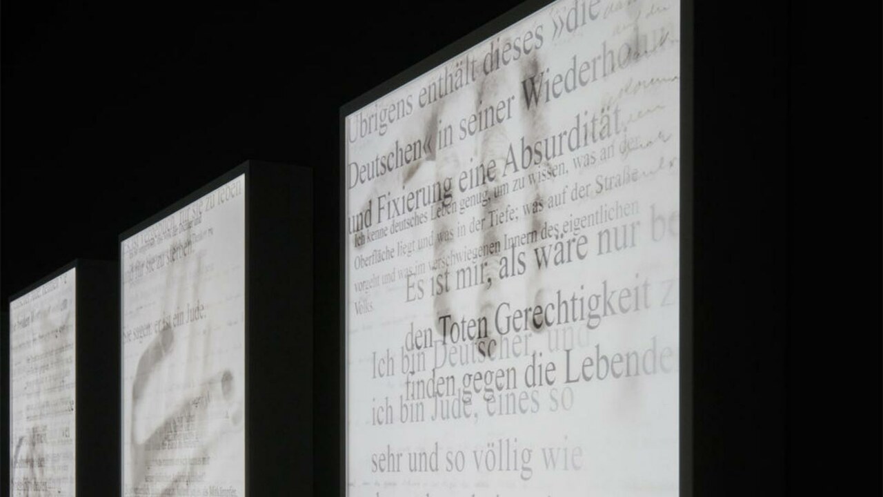 Auszüge aus den Schriften auf weißen Bildschirmen, die in schwarzen Wänden eingebaut sind