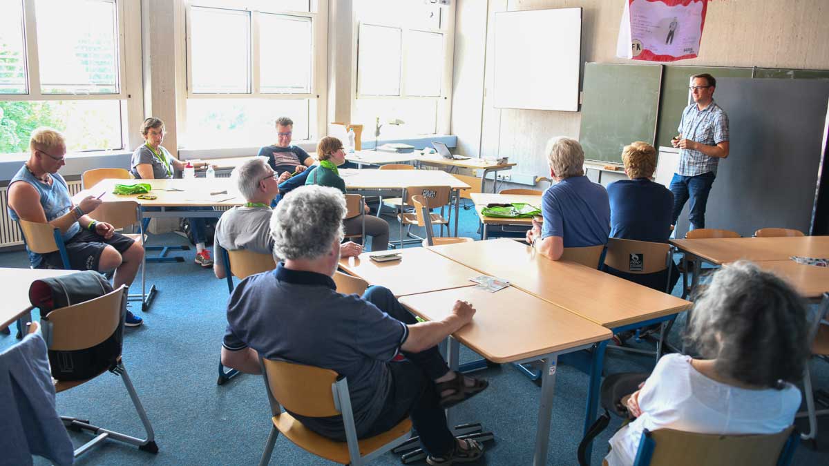 eine Gruppe Menschschen diskutiert bei einem Workshop in einem Klassenzimmer