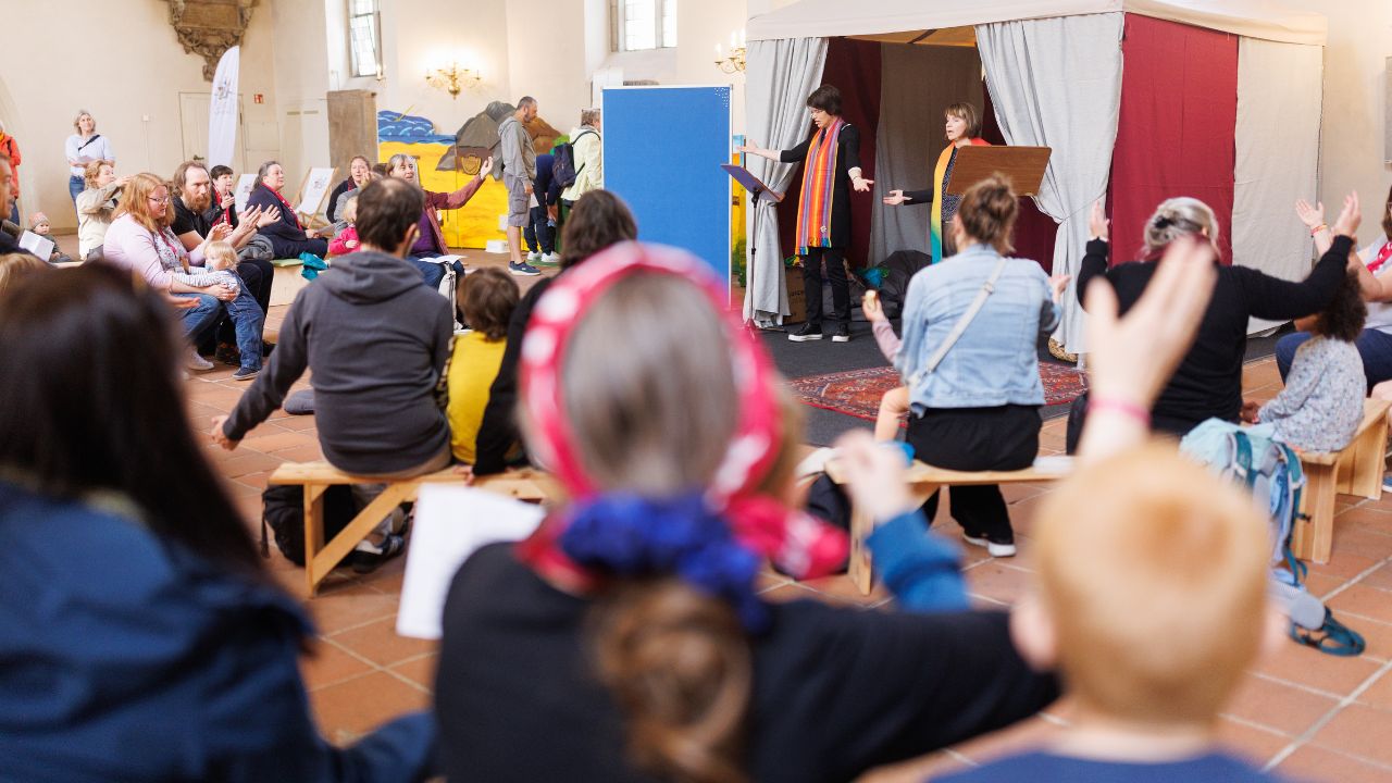 Menschen sitzen in der Kinderkathedrale und nehmen an einer Veranstaltung teil
