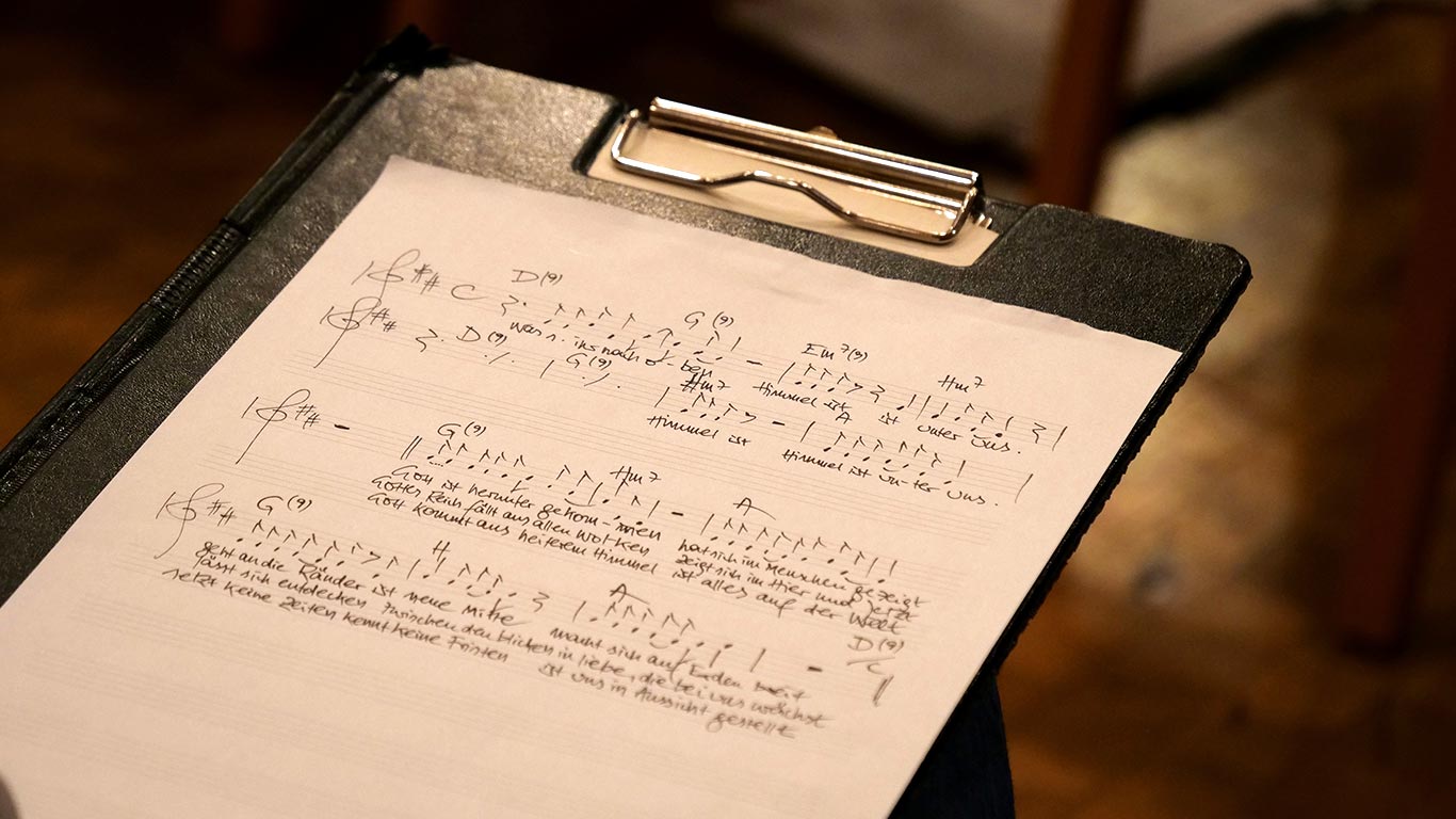 Klemmblock mit handgeschriebenen Noten Schwarzes Klemmbrett mit handgeschriebenen Noten