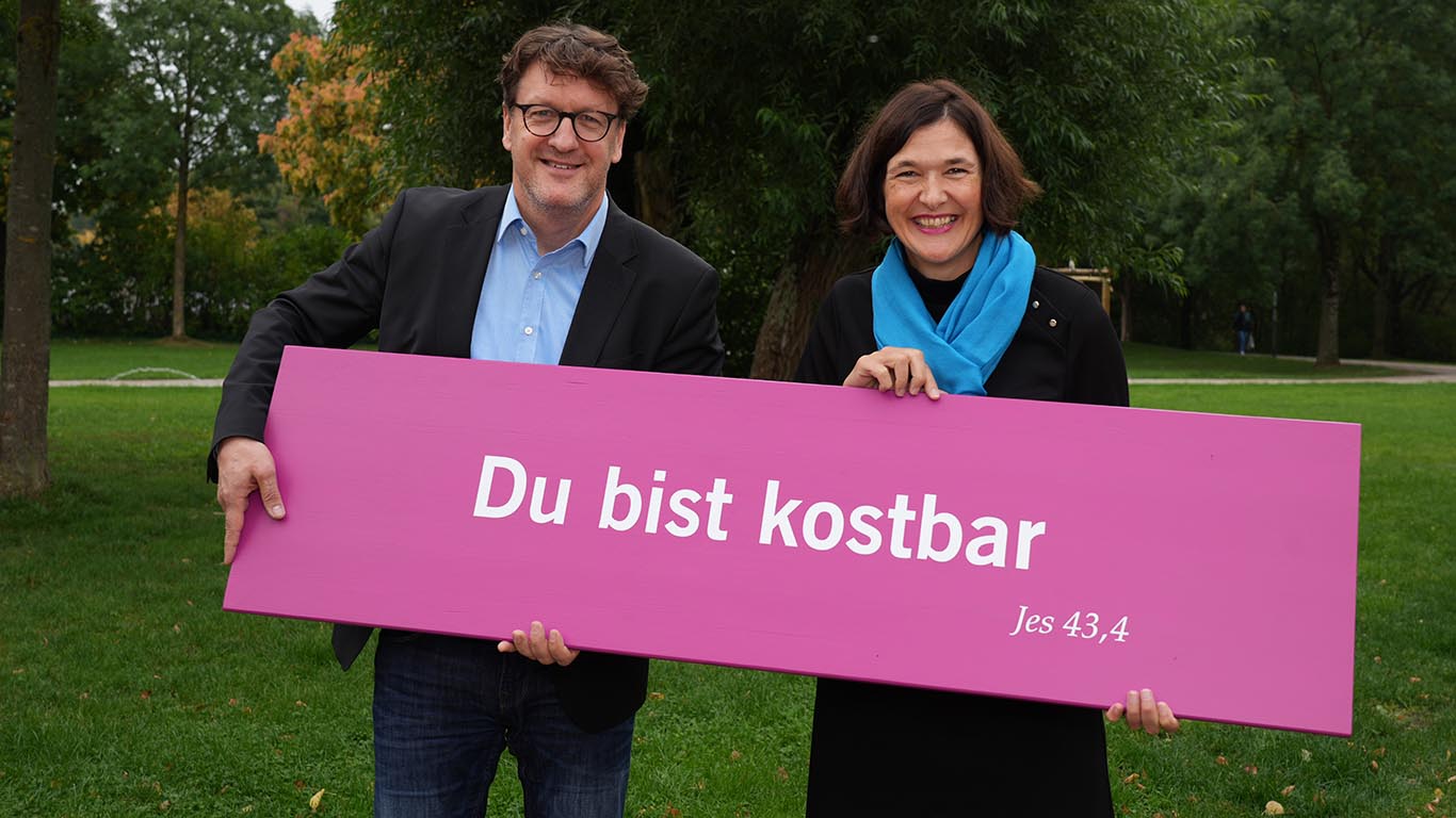 Kirchentagspräsident Torsten Zugehör und Generalsekretärin Kristin Jahn halten eine Platte mit der Losung für den Kirchentag 2027 in Düsseldorf.