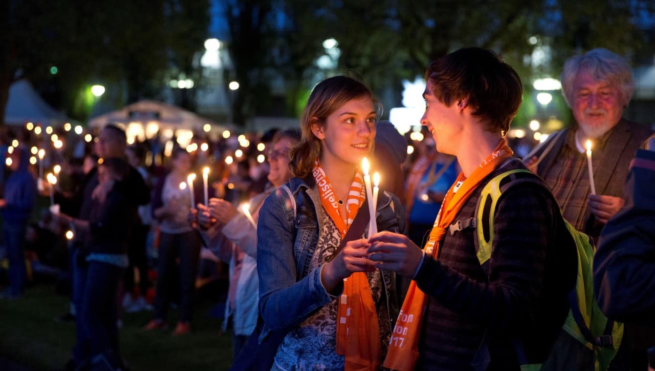 Paar beim Abendsegen - Kirchentag Berlin - Wittenberg 2017 (Foto: DEKT/Kay Michalak) Ein junges Paar schaut sich lächelnd in die Augen während sie die weißen Kerzen zum Abendsegen angezündet zwischen sich halten