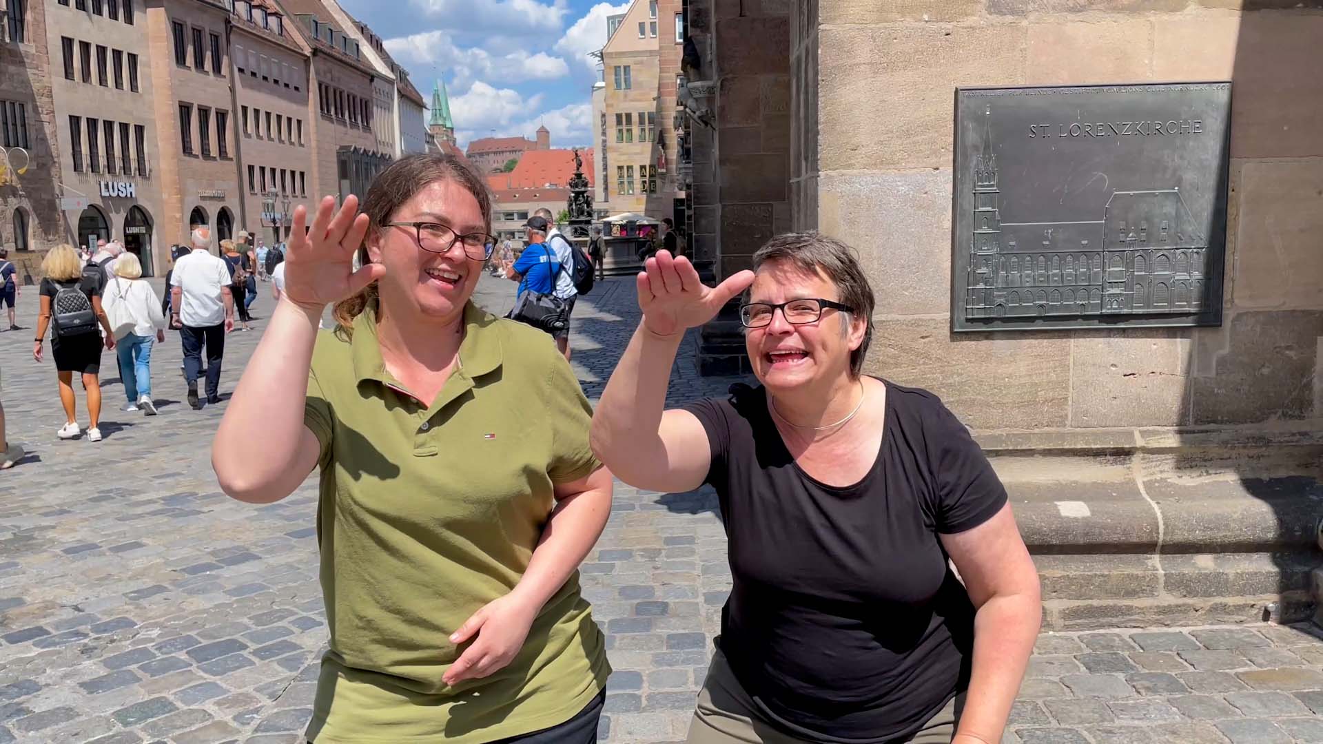 Zwei Frauen bei der Gebärde "Ade" in der Nürnberger Altstadt.