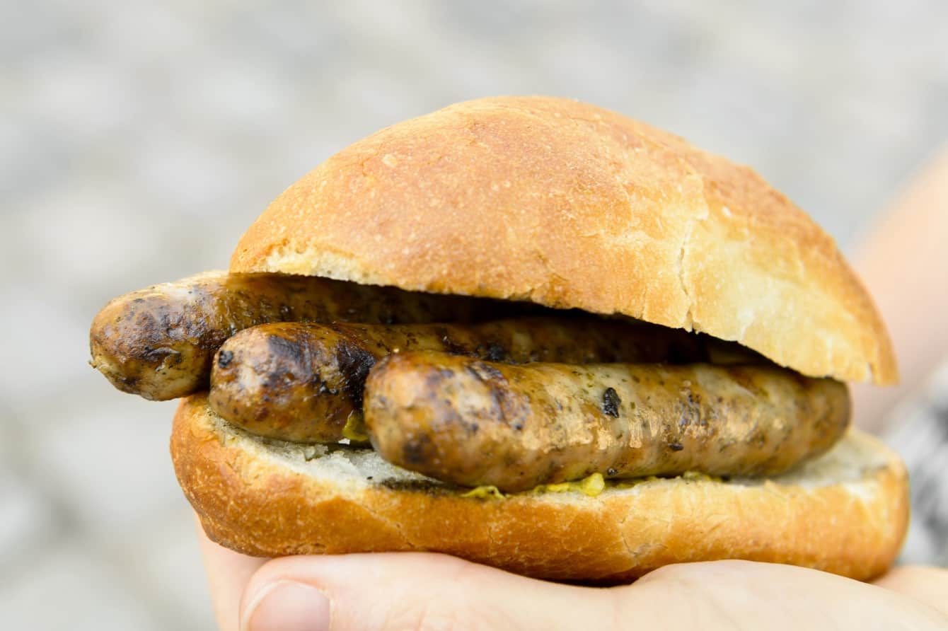 drei fingerlange Bratwürste in einem Brötchen