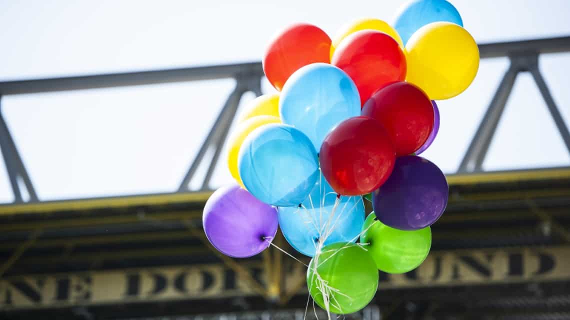 Traube bunte Luftballons als Symbolbild "Alle gehören dazu" - beim Schlussgottesdienst in Dortmund 2019, im Hintergrund das Dach des Signal Iduna Parks